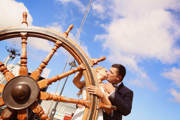 Bride and groom holding old boat steering wheel - Φωτογραφία, εικόνα