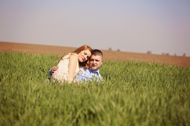Hermosa pareja alegre que pone en la hierba verde
 - Foto, imagen