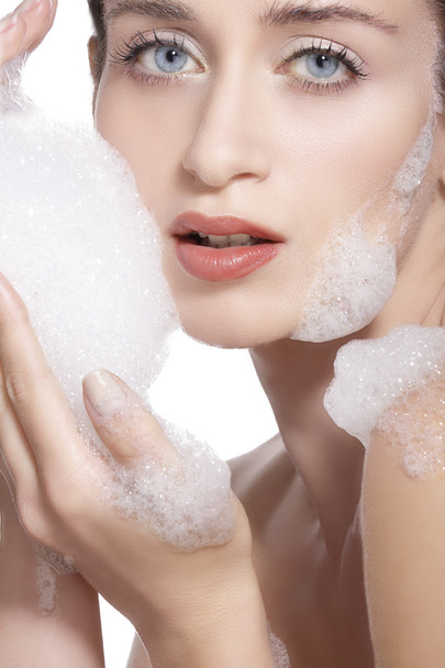 Beautiful woman cleaning her face with a foam treatment  - Foto, Bild