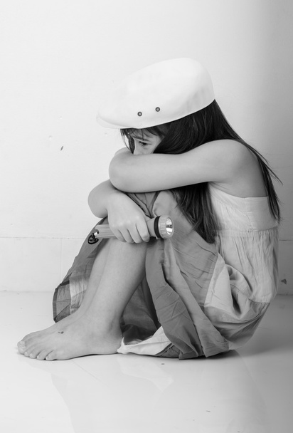 Κοριτσάκι με τη λάμψη ελαφριά κάθεται με scarely - Φωτογραφία, εικόνα