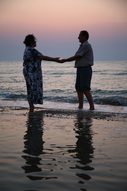 Grandfather with grandmother on sunset at sea - Valokuva, kuva