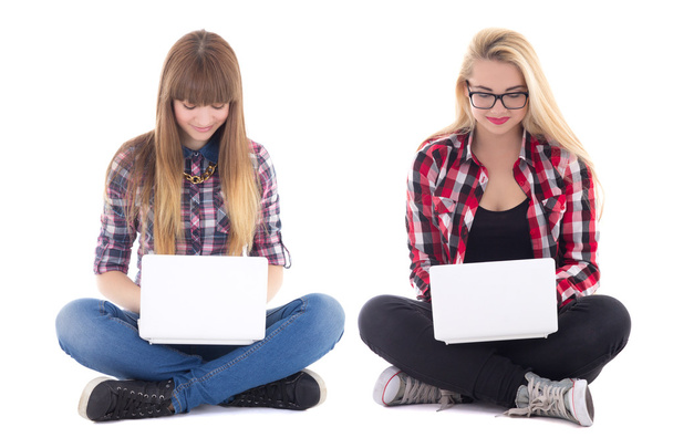 two teenage girls sitting with laptops isolated on white - Photo, Image