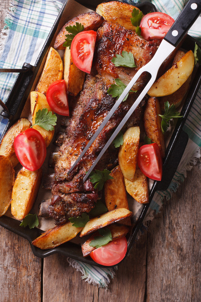  La comida casera: la carne de cerdo, las patatas y los tomates en la cacerola. vertical t
 - Foto, Imagen