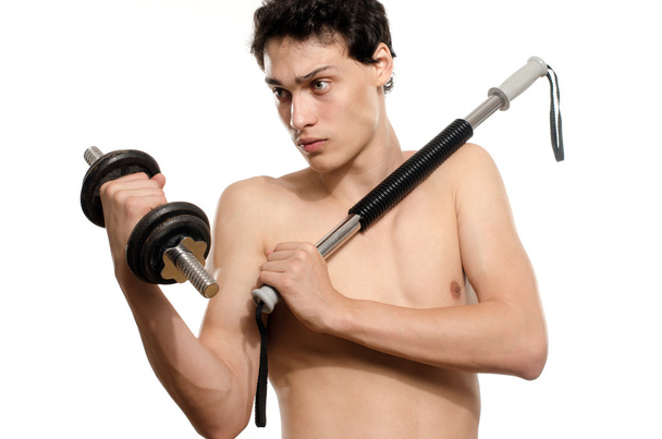 Skinny man training his bicep muscle. Beautiful teenager lifting a dumbbell.Anorexic young man training to become stronger, flexing a bendy bar - Valokuva, kuva