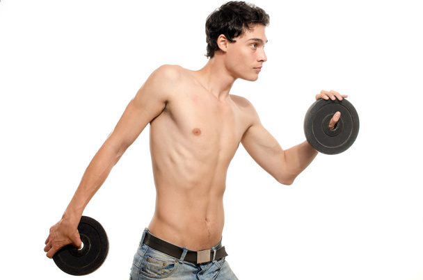 Skinny man training his bicep muscle. Beautiful teenager lifting two dumbbells.Anorexic young man training to become stronger - Foto, Imagem
