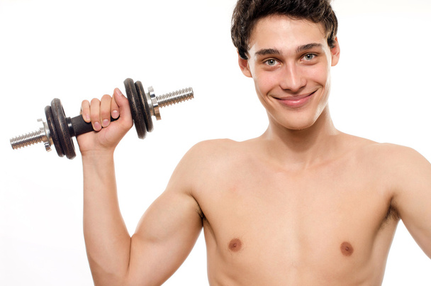 Homem magro a treinar o músculo bíceps. Adolescente bonita levantando um hall.Anorexic jovem treinamento para se tornar mais forte
 - Foto, Imagem