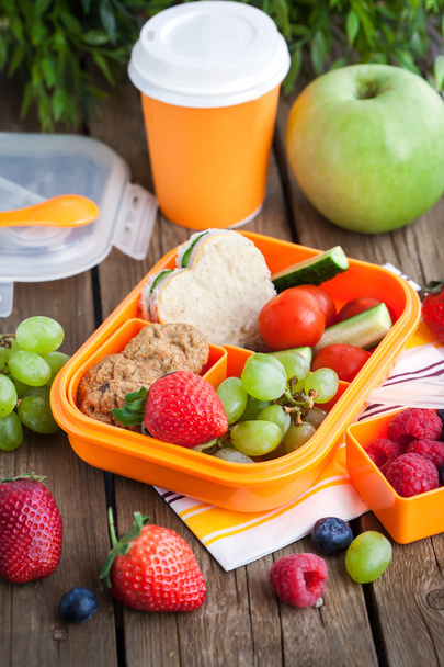 Lunchbox met sandwich, koekjes, groenten en fruit - Foto, afbeelding