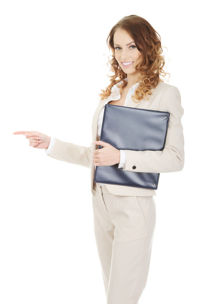Happy businesswoman pointing with clipboard. - Fotó, kép