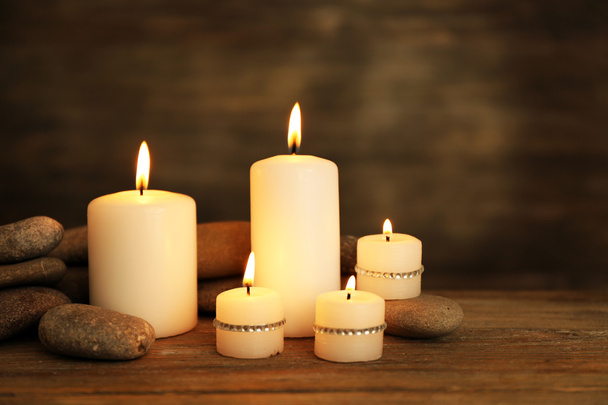 Beautiful composition with candles and spa stones on wooden background - Foto, imagen