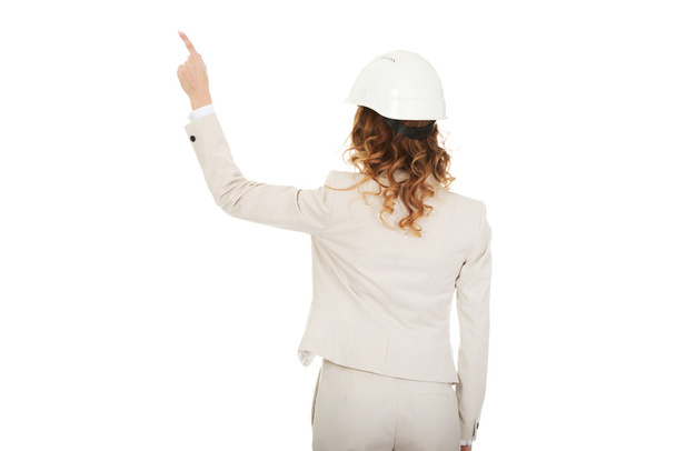 Businesswoman in white helmet pointing up. - Fotó, kép