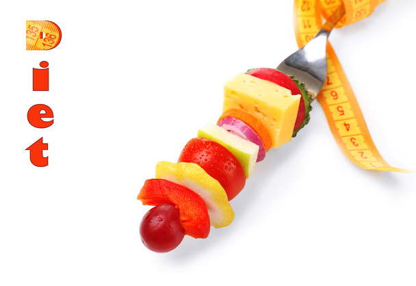 Snack de verduras en tenedor con cinta métrica aislada en blanco
 - Foto, imagen