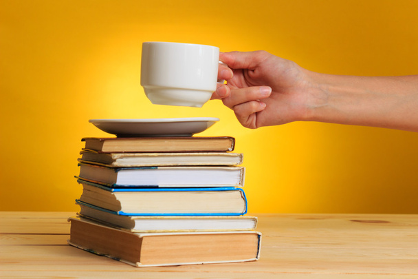 Könyvek, nő kezében egy fehér kupa - Fotó, kép