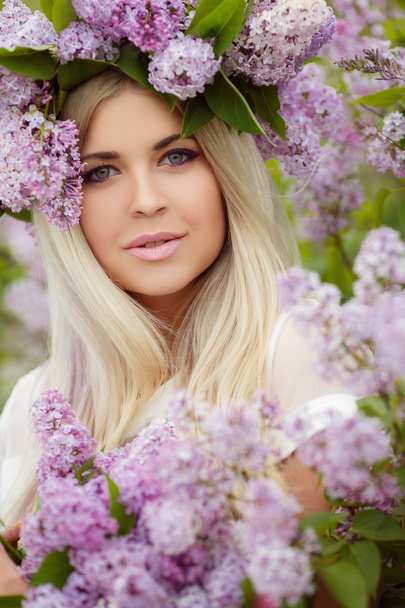 Spring portrait of a beautiful girl with lilac. - Foto, Imagem