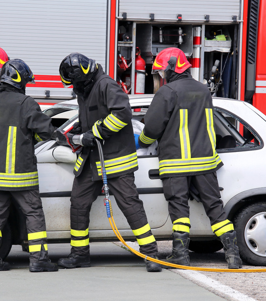brandweerlieden verlichten een gewonde na een auto-ongeluk - Foto, afbeelding