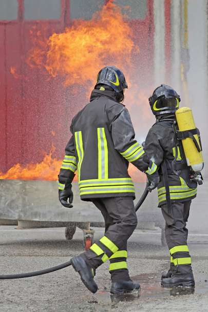 δύο πυροσβέστες με φιάλες οξυγόνου από τη φωτιά - Φωτογραφία, εικόνα
