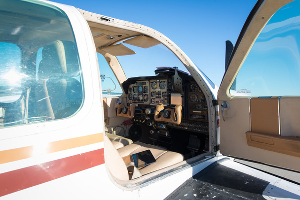 Cockpit eines kleinen weißen Propellerflugzeugs am blauen Himmel - Foto, Bild