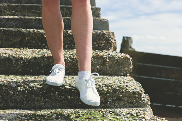 As pernas de uma mulher descendo escadas
 - Foto, Imagem