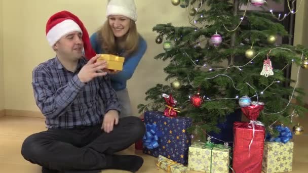 Όμορφη γυναίκα παρόντες φουλάρι δώρο Χριστουγέννων για το σύζυγό της - Πλάνα, βίντεο
