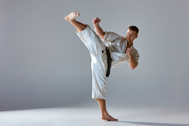 Man in white kimono training karate - Foto, afbeelding