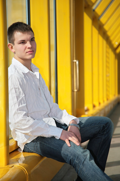 Young man sits on footbridge - Φωτογραφία, εικόνα