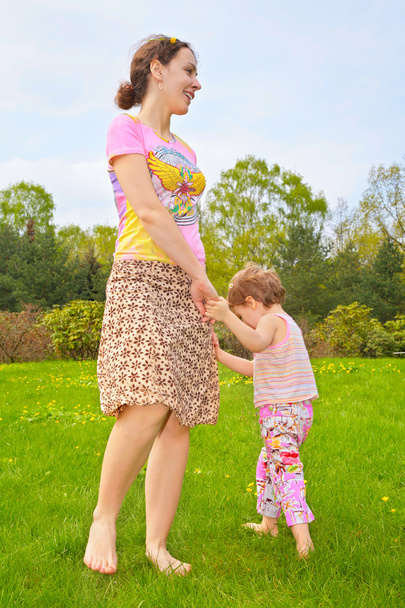 Mother with daughter walk barefoot on lawn - Φωτογραφία, εικόνα
