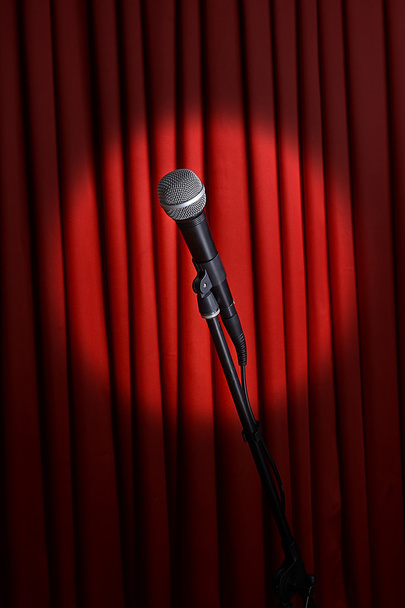Microphone on stand on red curtain background - Foto, imagen