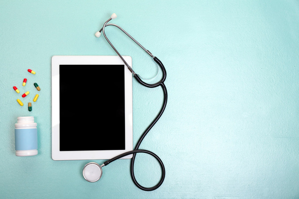 Medical tablet with stethoscope on blue background - Fotó, kép