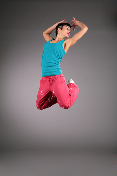 Dancing woman in sportswear jumps - Photo, Image