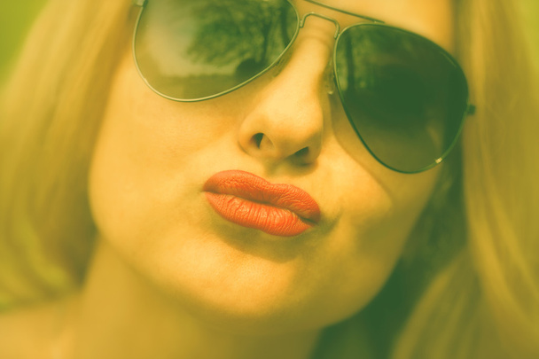 Το κορίτσι με τα γυαλιά ηλίου φιλί στα χείλη - Φωτογραφία, εικόνα