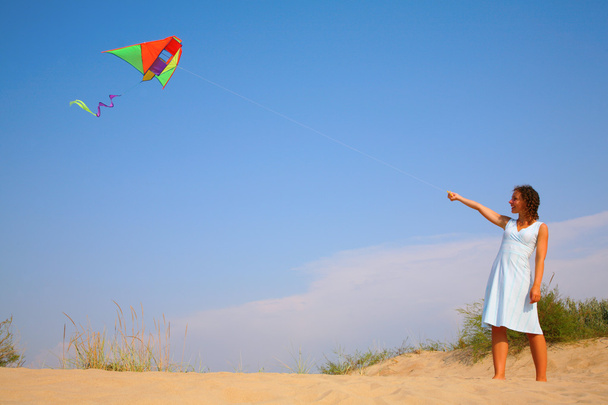 Дівчина в білій сукні біжить з повітряним змієм
 - Фото, зображення