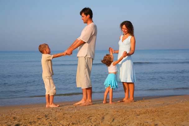 Parents with children standing at edge of sea - Foto, imagen