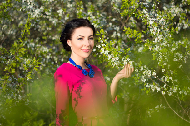 Porträt des jungen schönen Frau im Garten mit blühenden Bäumen - Foto, Bild