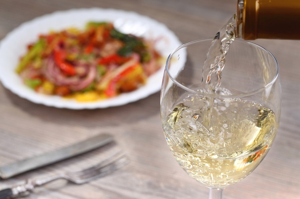 Pouring white wine and salad - Zdjęcie, obraz