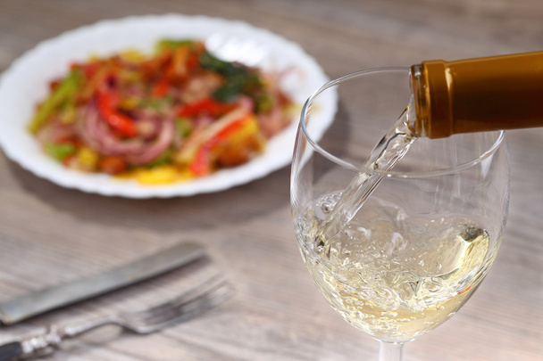 Pouring white wine and salad - Foto, Imagen