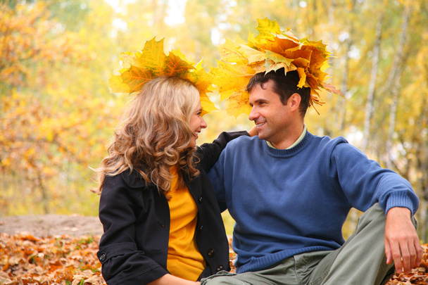 Пара с кленовыми листьями в осеннем лесу
 - Фото, изображение