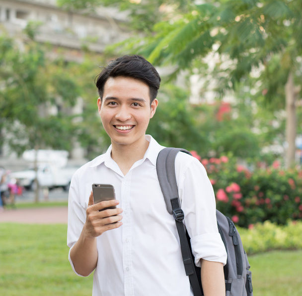 Feliz asiática joven estudiante utilizando el teléfono móvil
 - Foto, imagen