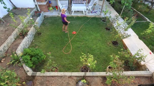mujer rubia regando el jardín
 - Metraje, vídeo