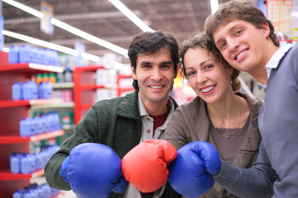 Three friends in boxing gloves in shop - Photo, image
