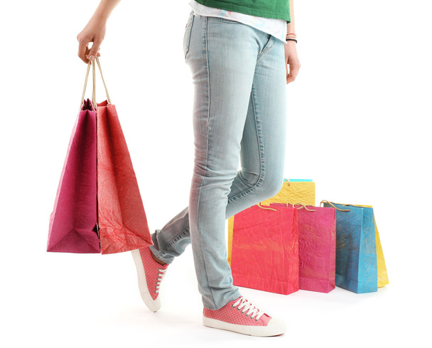 Kleurrijke winkelstraten papieren zakken in vrouwelijke handen geïsoleerd op wit - Foto, afbeelding