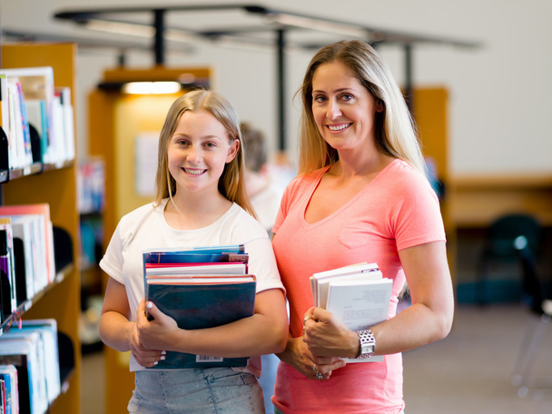 Girl and her mother in library - Foto, Bild