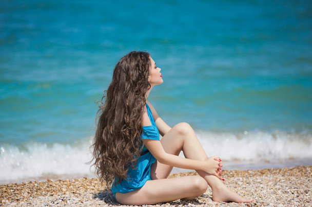 Menina morena nova desfrutando e tomando sol na praia com lo
 - Foto, Imagem