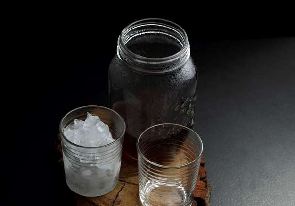 Filterkaffee in Gläsern mit heißem und kaltem Wasser auf einem Holzbrett auf dunklem Hintergrund mit Kopierraum. - Foto, Bild