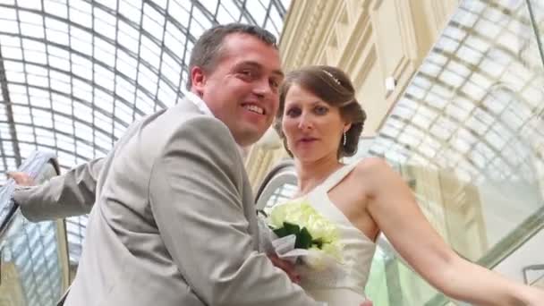Bride and groom on escalator - Кадры, видео