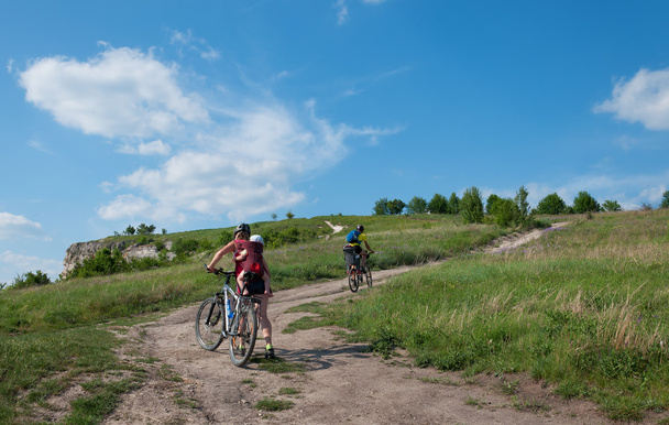 Сім'я з маленькими дітьми катання на гірських велосипедах на ґрунтовій дорозі
.  - Фото, зображення