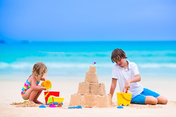 Crianças construindo castelo de areia na praia
 - Foto, Imagem