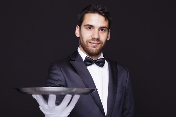 Camarero sosteniendo una bandeja de plata vacía
 - Foto, Imagen