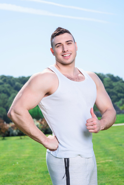 Handsome sportsman doing exercises outdoors - Photo, Image