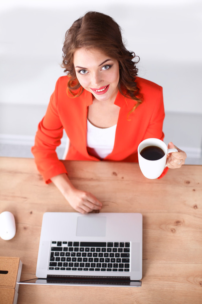 Attractive woman sitting at desk in office, working with laptop computer - Foto, Bild