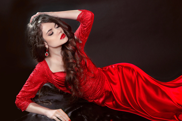 Woman in red lying in the dark. Fashion tempting girl model in s - Fotó, kép