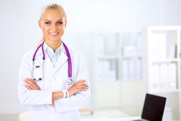 Portrait of young woman doctor with white coat standing in hospital - Photo, image